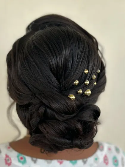 A close up of the detailed, woven bun with gold beads.