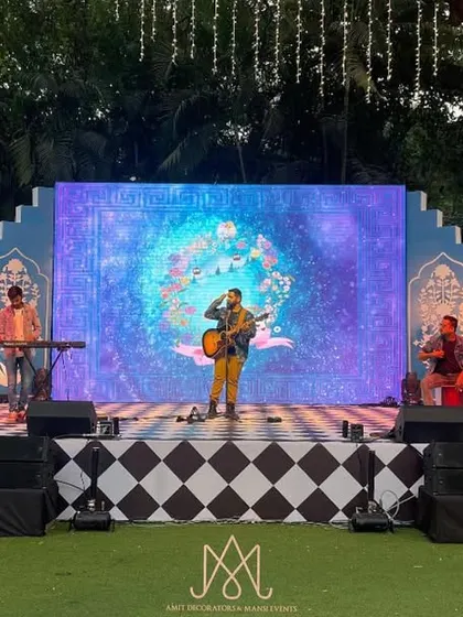 The Bar Palladio themed stage comes alive with a live band performance, set against a backdrop of intricate blue panels and a checkered floor.