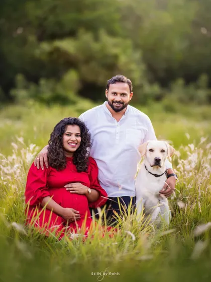 A classic portrait of an expecting couple and their handsome Labrador in a field of tall grass. This is a timeless shot that you'll want to frame and keep forever.