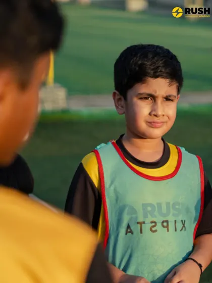 A young player looks on with focus and determination, ready for the next drill.