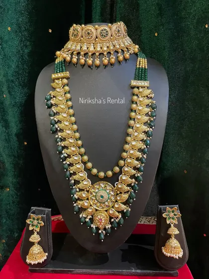 A stunning Kundan-style set with green beads and a large central pendant, perfect for a royal bridal look.