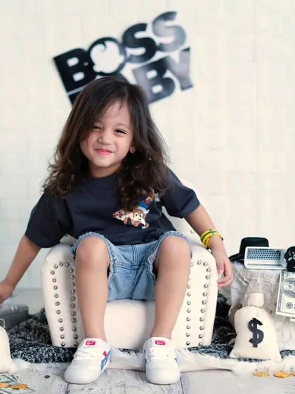A future model in the making. This older boy is rocking the 'Boss Baby' theme with his cool pose and confident smile.