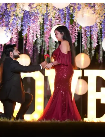 A beautiful proposal scene set against a backdrop of hanging flowers and lanterns. This pre-wedding setup is incredibly romantic and creates a magical atmosphere for the perfect shot.