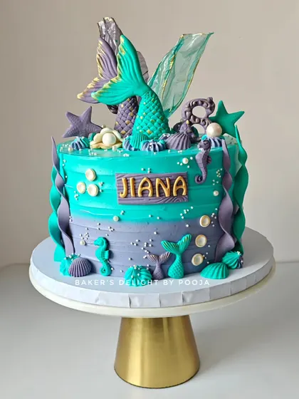 A vibrant mermaid theme cake in turquoise and purple for an 8th birthday. The design features shimmering mermaid tails, seahorses, and seashells for a beautiful under-the-sea party.