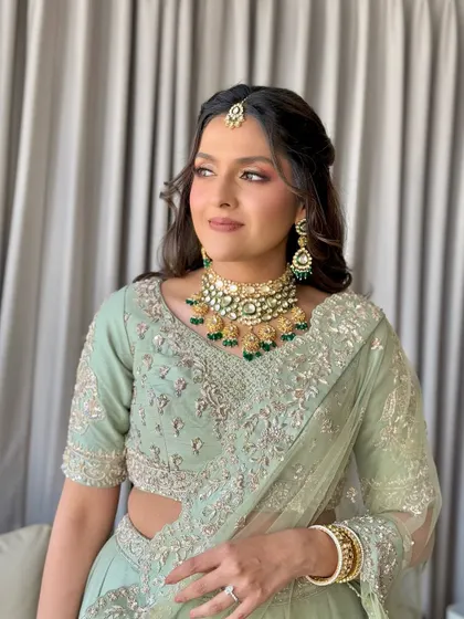 A side profile showcasing the intricate hairstyle and beautiful Kundan jewelry.