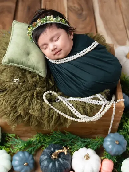 A sleeping pumpkin princess, adorned with a string of pearls.