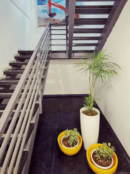 The industrial-style staircase with steel railings and dark treads, complemented by vibrant planters. This shows how we introduce pops of color and nature to soften industrial elements.