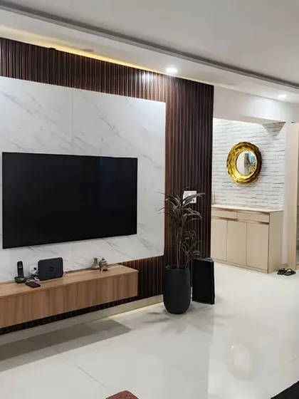 A wider shot of the living and dining area, showing how the modern TV panel complements the classic wall molding and elegant dining set. It's a beautiful blend of contemporary and timeless design.