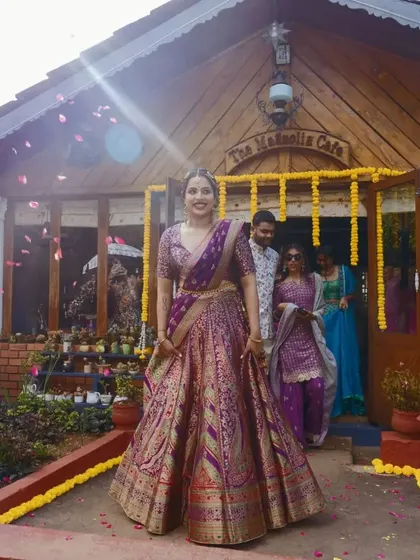 A beautiful shot of the bride at her Mehendi ceremony, with a shower of petals adding a touch of magic to her entrance.