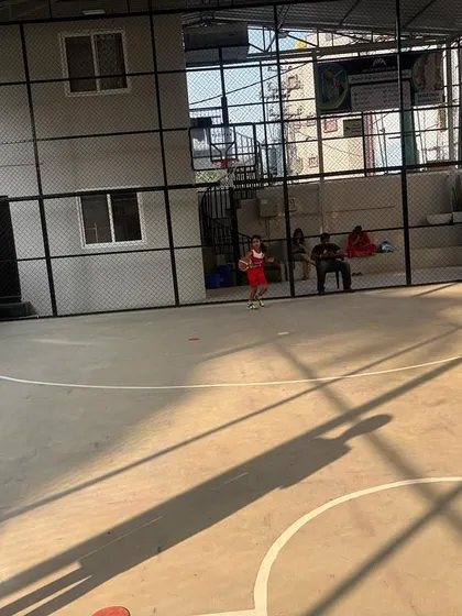 A young girl runs with the ball on the court, showing the dynamic movement and energy of our basketball sessions.