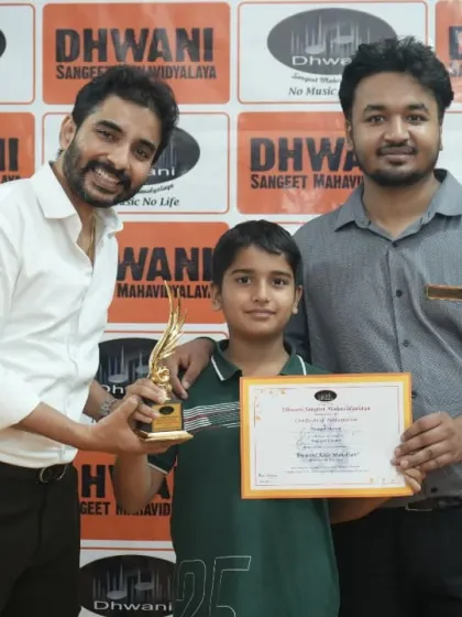 Two teachers present an award to their student.