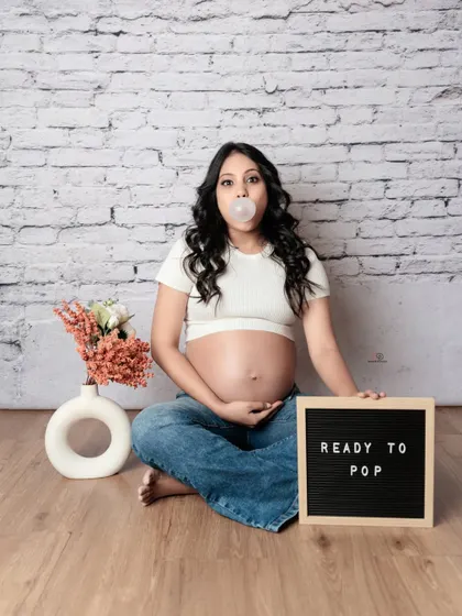 Ready to pop! A fun and casual studio shot with a playful prop and a bit of bubblegum. Maternity shoots can be serious and glamorous, but they can also be lighthearted and fun.