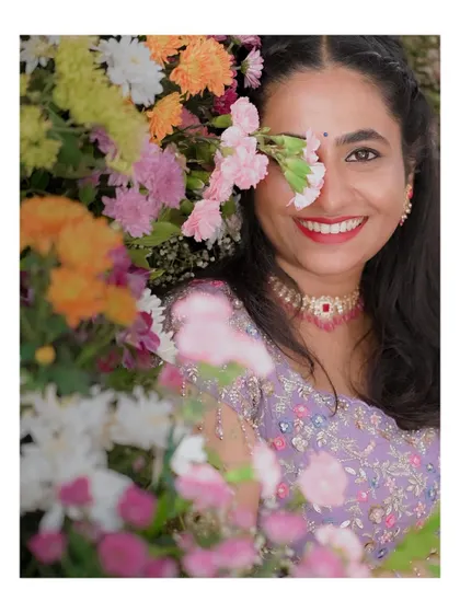 A happy bride peeking through a wall of colorful flowers. This shot is playful, vibrant, and full of life.
