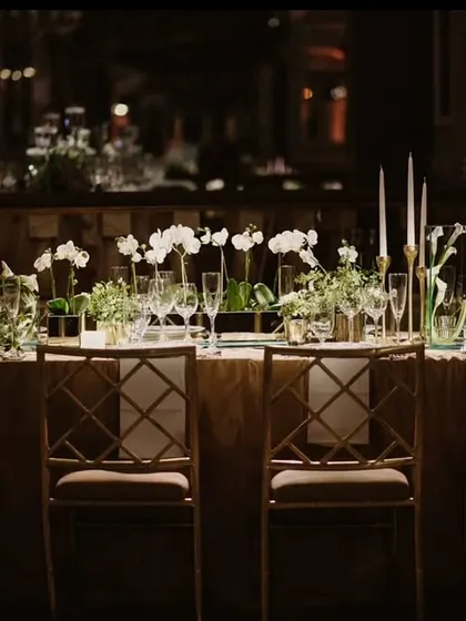 A long, beautifully decorated dining table set for an elegant evening event.