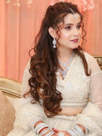 A solo portrait of the engagement bride, her curly hair and soft makeup creating a romantic and youthful look.