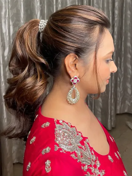 This client exuding charm and elegance in a vibrant red outfit, with a chic ponytail.