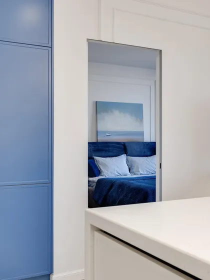 A clever design detail: a mirrored niche offers a glimpse into the bedroom, creating a sense of depth and connection between spaces.
