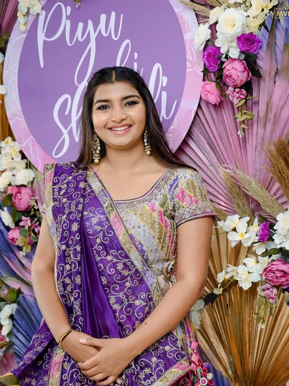 A close-up of the bride, her happiness shining through, framed by the floral and palm leaf decor.