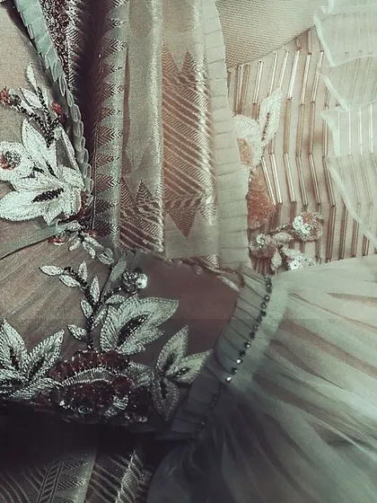 An abstract close-up that captures the textures and details of the embroidery, beading, and fabric. This artistic shot emphasizes the quality and artistry of the garment in a non-traditional way.