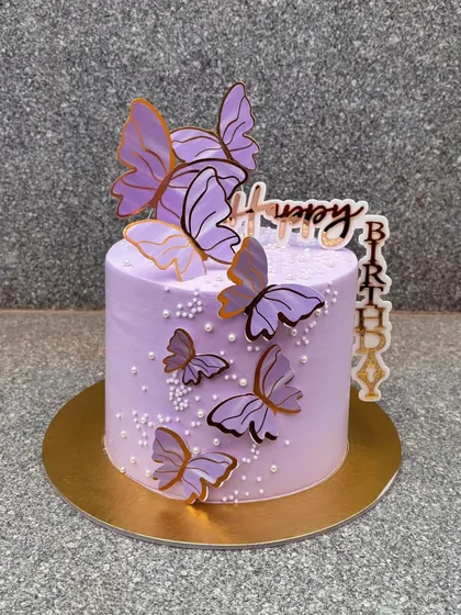 A simple yet stunning lavender butterfly cake. The gold-outlined butterflies and vertical "Happy Birthday" topper add a touch of modern elegance.