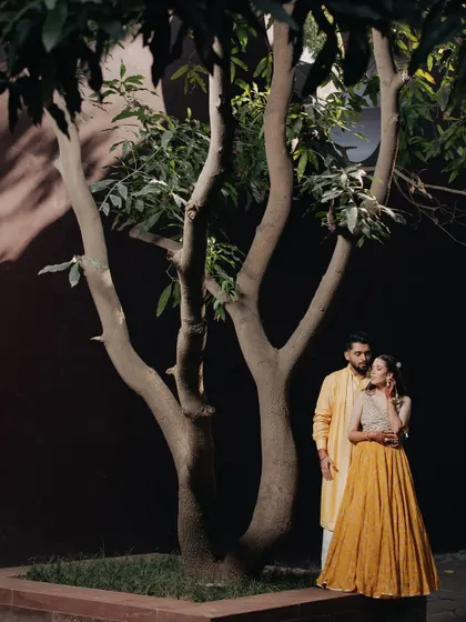 A quiet, romantic portrait by a tree. The composition and lighting create a sense of intimacy and peace.