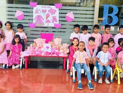 Students gather for a group photo in front of the Pink Day decorations, showing off their festive pink outfits.