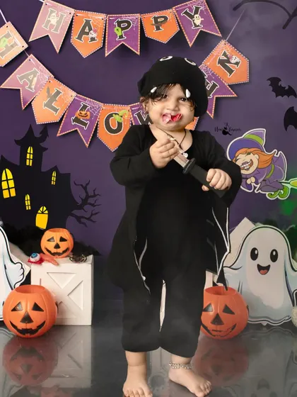 A playful vampire with a bit of 'blood' (safe and edible!) on his mouth for a fun and spooky effect.