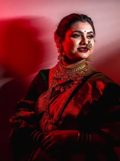 A striking portrait with dramatic red backlighting, giving the bride a powerful and cinematic presence.