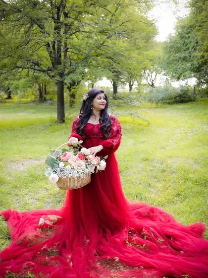 A duplicate of image 368, this outdoor portrait captures a fairytale moment with the mom-to-be in a red gown, surrounded by the beauty of nature.