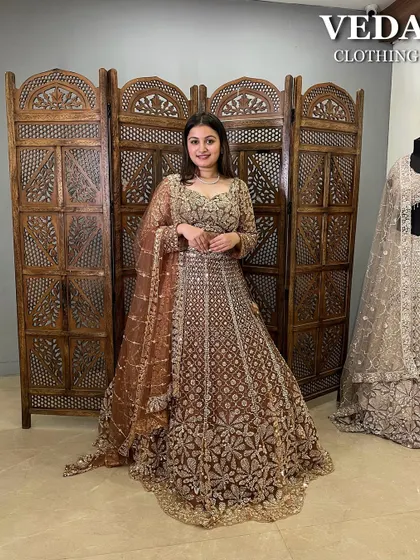 Not all brides wear red, and this magnificent pre-loved bridal lehenga proves why. The rich brown fabric is covered in dense, shimmering gold floral embroidery, creating a truly grand and unforgettable look.