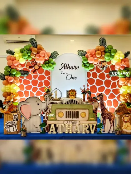 A safari jeep theme for Atharv's first birthday, with giraffe-print backdrops and animal cutouts.