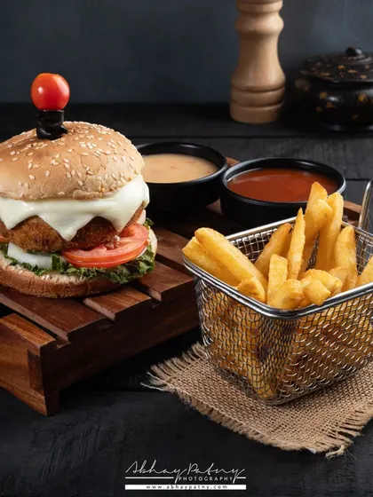 A classic burger and fries combo. The dark, rustic styling gives it a gourmet pub feel, while the lighting ensures the burger looks juicy and the fries look crispy.
