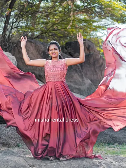 This wine-colored gown features a beautifully embroidered sleeveless top and a full, flowing skirt that creates a stunning effect.