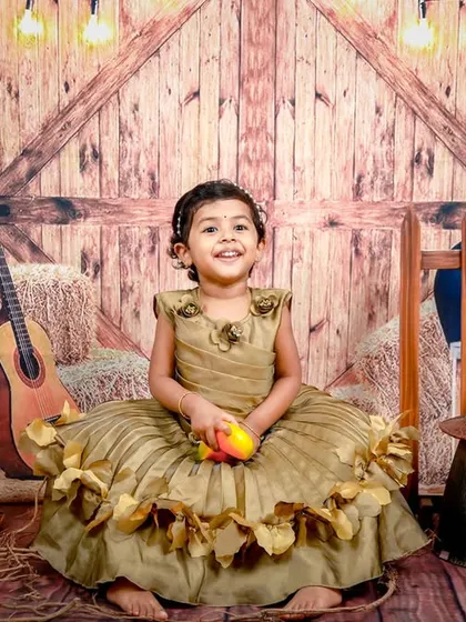 A happy little cowgirl enjoying our rustic barnyard setup. The warm lighting and wooden textures create a cozy and inviting atmosphere.