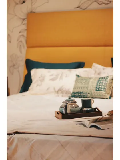 A close-up of a luxurious bed with an orange full Italian leather frame, styled for ultimate comfort.