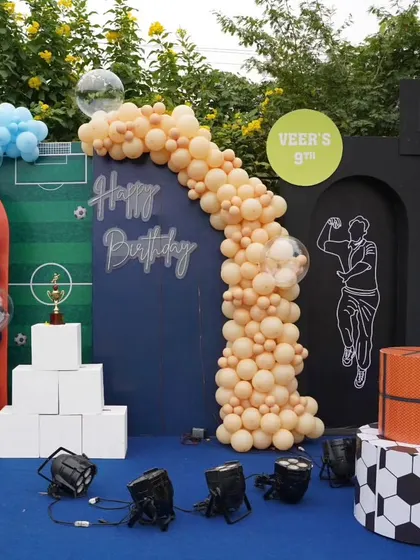A wide view of the sports-themed backdrop for Veer's 9th birthday, combining elements of cricket, basketball, and soccer.