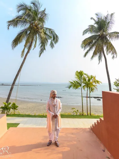 The groom posing against the beautiful beach backdrop of his Goa wedding venue.