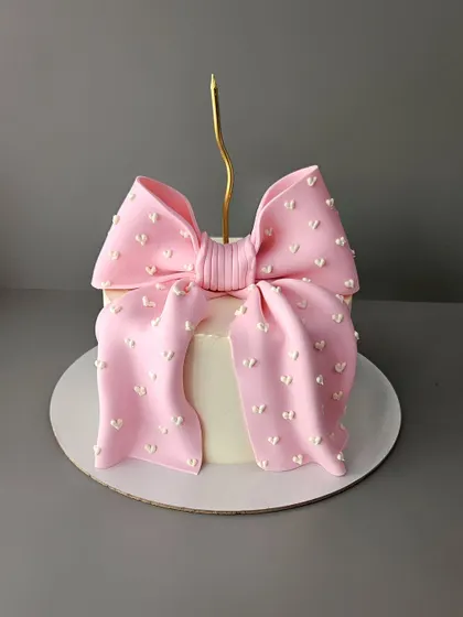 A simple yet stunning pink bow cake. This elegant design is perfect for any celebration for her, from birthdays to anniversaries. The oversized fondant bow makes a beautiful statement.