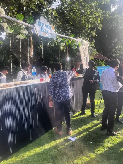 Guests gathering at our "Resto Bar" during a sunny outdoor wedding event. We love being the spot where everyone comes together to chat and grab a drink.