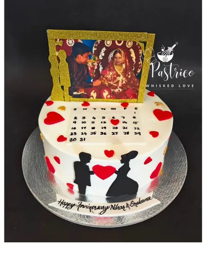 A personalized anniversary cake featuring an edible photo of the couple, a calendar marking their special day, and a romantic silhouette.