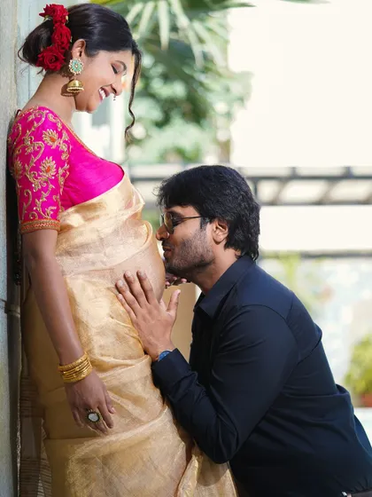There is so much joy in anticipation. This is a close, intimate moment from a maternity photoshoot, capturing the partner's connection to the baby bump in a way that feels warm and genuine.