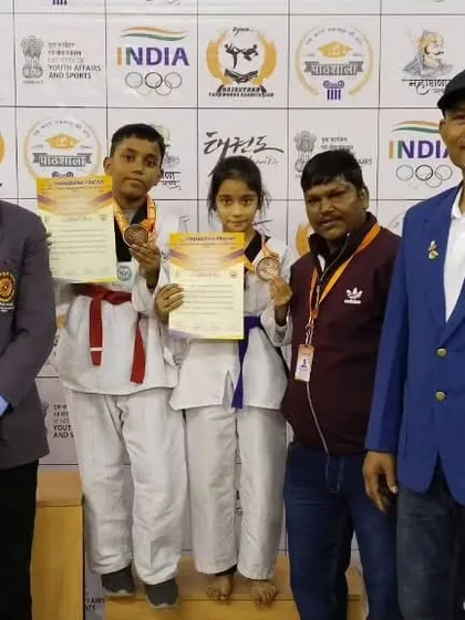 Naysha and Rohan on the podium after winning medals in the poomsae pair category at the national championship.