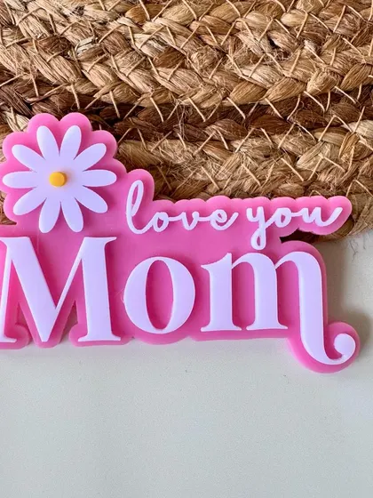 "Love you Mom" in a vibrant pink. These layered acrylic charms are designed to make moms feel special.