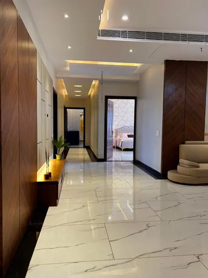 This long hallway is designed with elegant wood paneling and integrated lighting to create a warm and welcoming passage. It connects the different areas of the home while maintaining a cohesive and luxurious feel.
