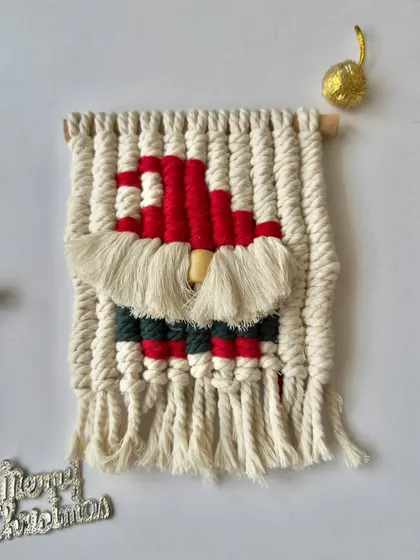 The macrame Santa wall hanging, with a fluffy white beard and classic red hat.