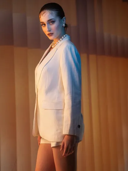A sophisticated and minimalist look. I used a combination of warm and cool lighting against a simple, textured background to sculpt the lines of the white suit and create a chic, modern portrait.