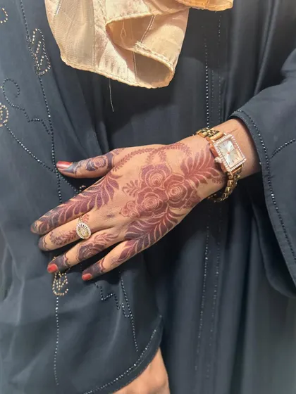 Another look at the same Eid henna design, this time styled with a black abaya. The dark stain stands out beautifully and is perfect for festive occasions.