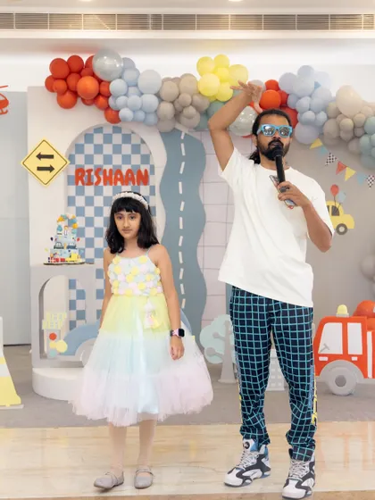 An entertainer engages with a young guest on the vehicle-themed stage, showing the fun and interactive atmosphere we create.