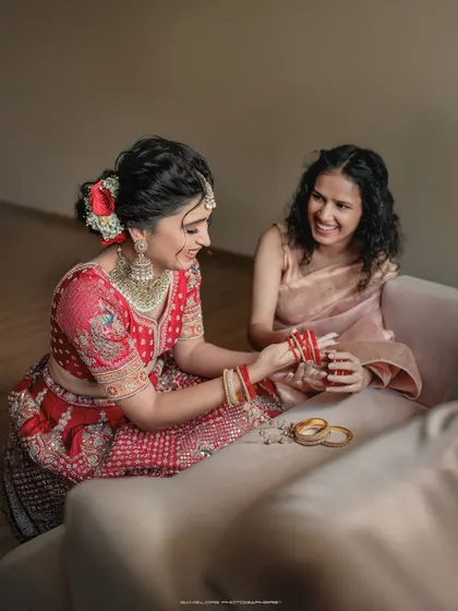 The bride sharing a laugh with her bridesmaid while getting ready. These behind-the-scenes moments are full of genuine friendship and excitement.