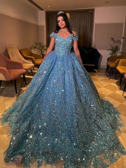 Here is one of my clients looking like a true princess in a fully embellished ice-blue ball gown. This rental gown is perfect for an engagement or reception, featuring off-shoulder sleeves and a voluminous skirt that sparkles with every movement.